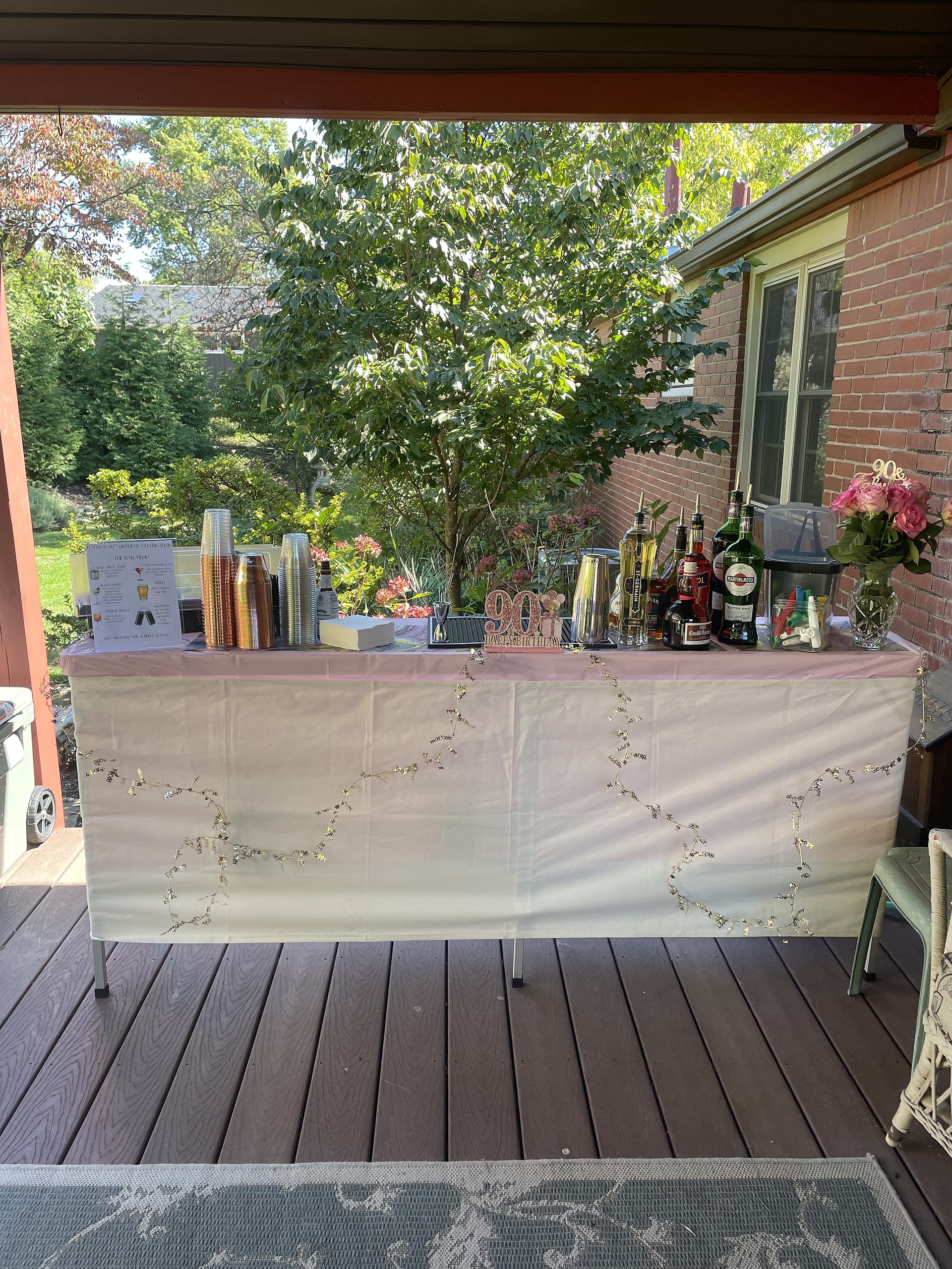 A styled pop-up bar set up on a covered deck for a birthday party